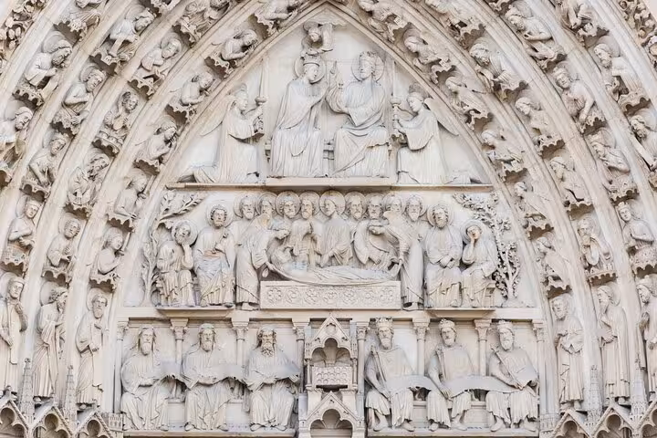 Close-up of Notre-Dame Cathedral portal sculptures, Gothic biblical carvings on a private historical tour in Paris