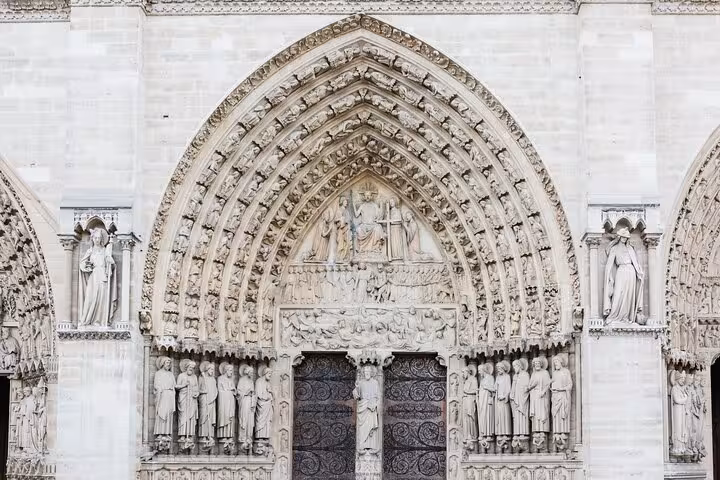 Notre Dame Cathedral portal with statues and ornate arches, family-friendly kids outdoor guided tour Paris