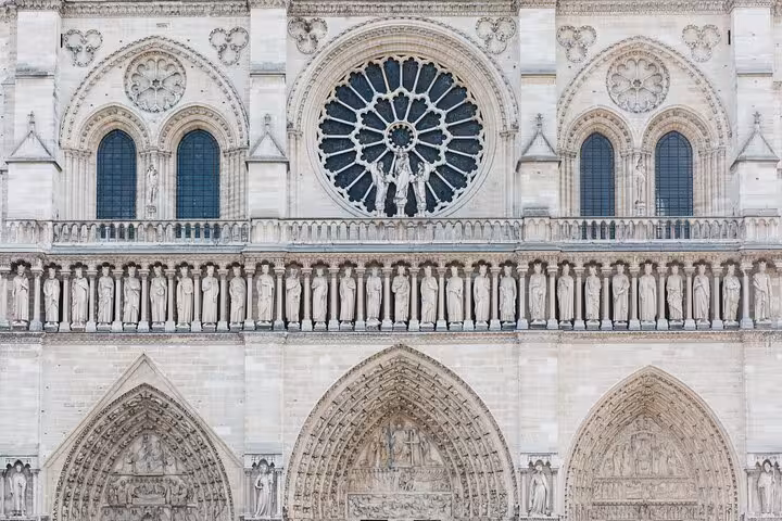 Close-up of Notre-Dame west facade rose window and statues, ideal for a private historical tour in Paris