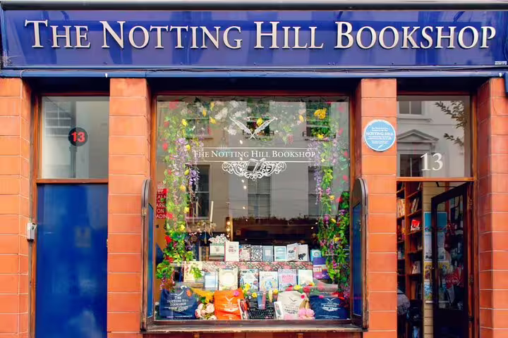 The Notting Hill Bookshop storefront with blue sign, flower-decorated window display at number 13