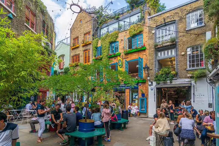 Vibrant scene in Notting Hill courtyard with colorful buildings and lively crowds, perfect for a private London tour experience.