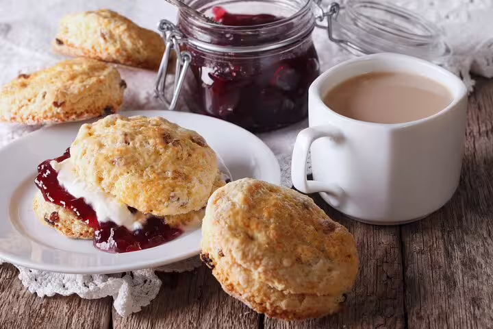 Delight in traditional English cream tea with scones, clotted cream, and jam during your Notting Hill private tour in London.