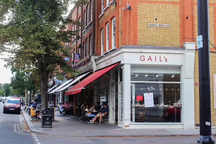 Charming Notting Hill street scene with outdoor café seating, highlighting vibrant market atmosphere on a London private tour.