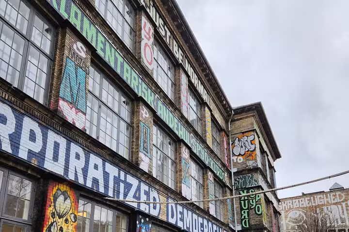 Colorful graffiti-covered building showcasing Copenhagen's vibrant urban art scene on a walking tour.