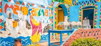 Colorful Nubian village mural with vibrant blue walls and traditional artwork in Aswan