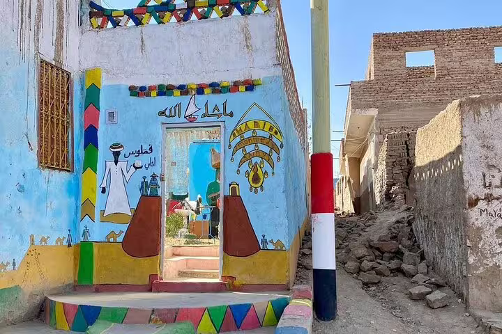Colorful Nubian Village entrance mural in Aswan, stop on private motorboat tour with guide and transfers