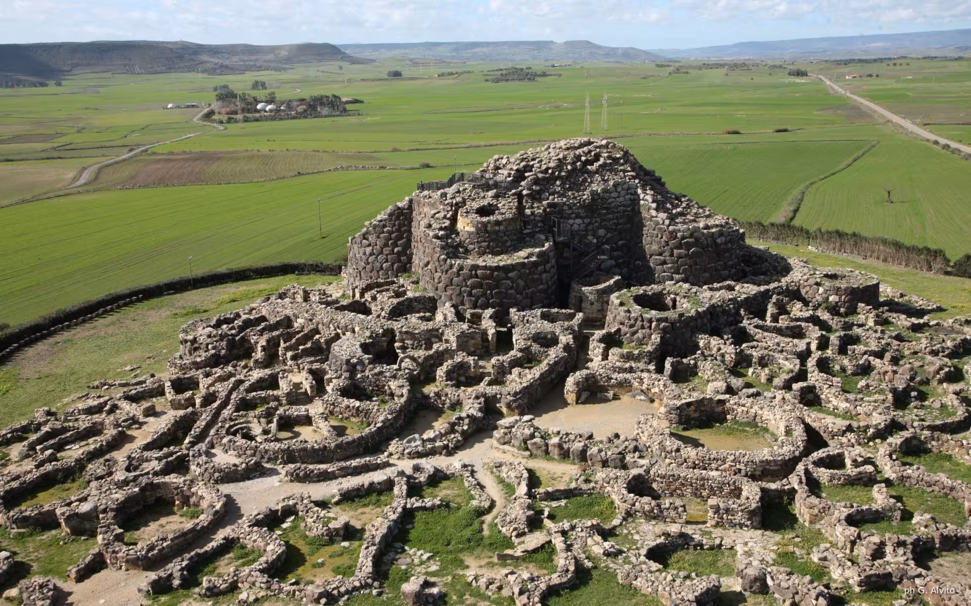 Aerial view of the Nuraghe Su Nuraxi complex in Barumini, showcasing ancient Sardinian architecture.