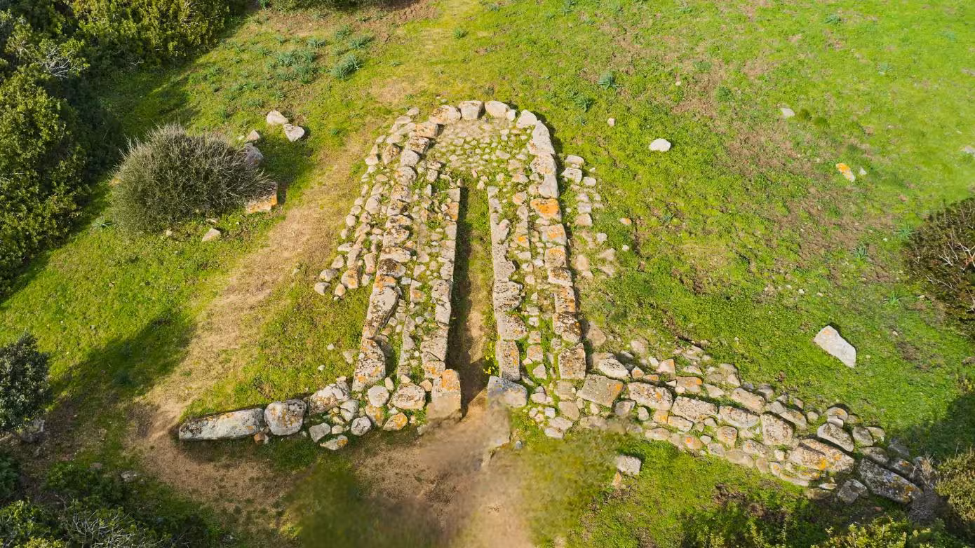 Aerial view of Nuragic stone ruins amidst lush greenery in Santa Teresa Gallura, perfect for archaeological exploration.