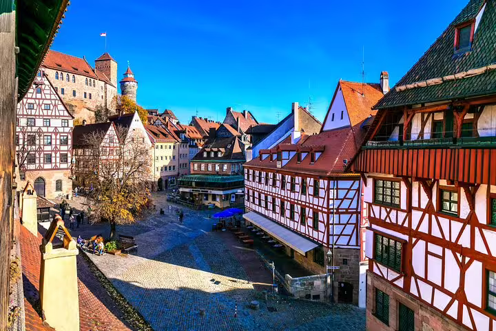 Medieval half-timbered buildings and cobblestone square in Nuremberg's historic old town with castle in background