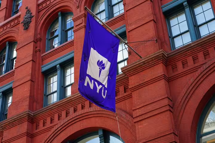 NYU purple flag hanging on red brick building facade in SoHo New York City