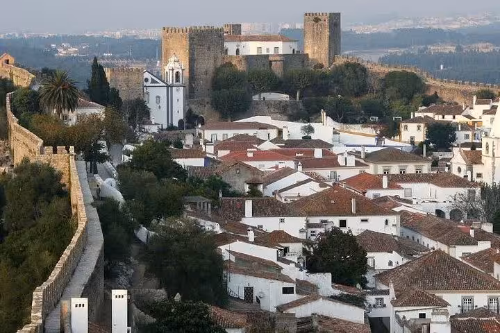 Obidos medieval castle and whitewashed village rooftops, historic stop on Lisbon to Porto transfer tour