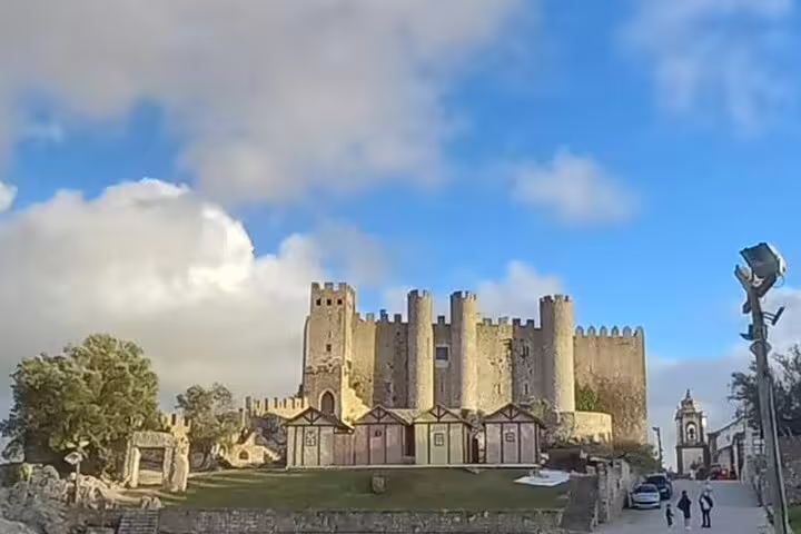 Historic Obidos Castle under a blue sky, capturing the medieval charm of Portugal on a Fatima-Nazare-Obidos private tour.