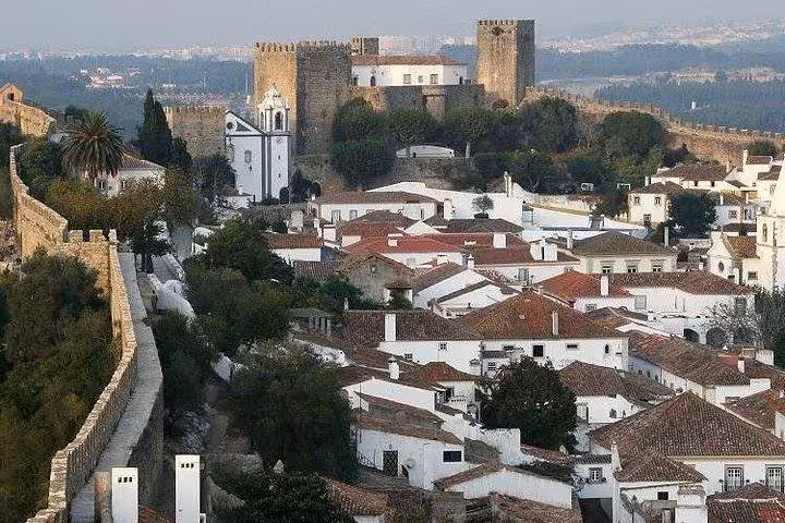 Obidos castle walls and whitewashed village rooftops, essential stop on Coimbra Nazare and Obidos day tour