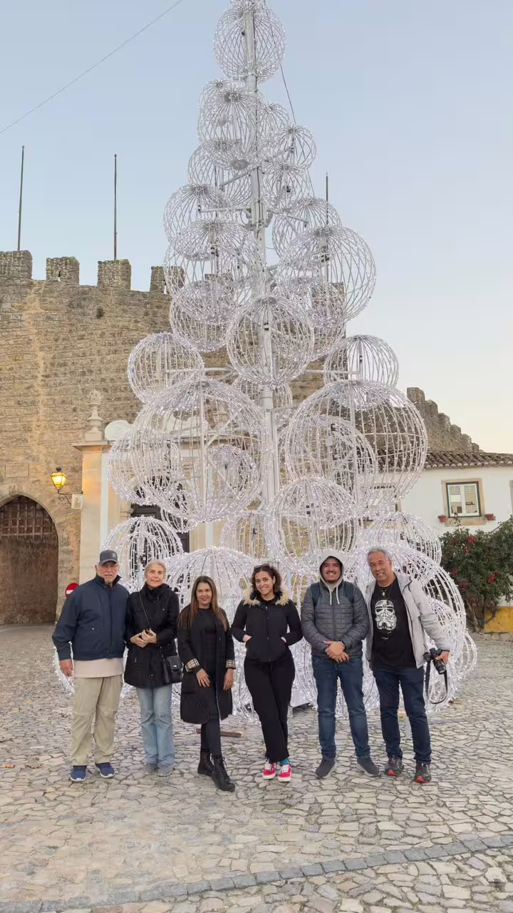 Tourists standing in front of a festive sculpture in Óbidos during a guided tour from Lisbon.