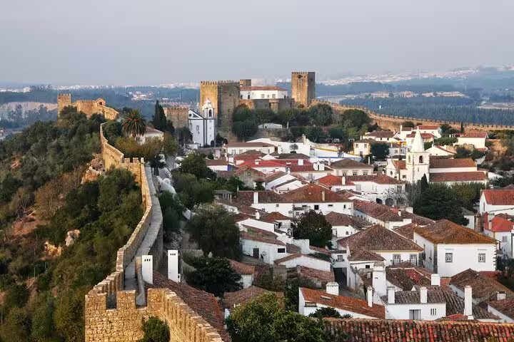 Scenic view of Óbidos with medieval castle walls and charming whitewashed houses, part of the Fátima, Nazaré, Batalha tour.