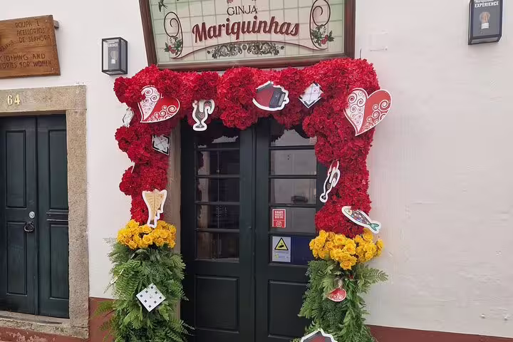 Charming Óbidos storefront with vibrant floral decorations, a highlight on the Porto to Lisbon tour.
