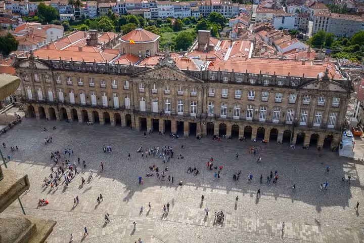 Aerial view of Obradoiro Square in Santiago de Compostela, bustling with tourists and historic architecture.