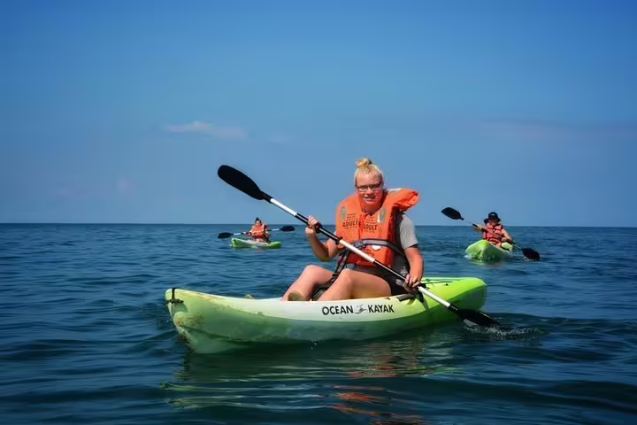 Group kayaking adventure in Manuel Antonio with vibrant ocean views under a clear blue sky.
