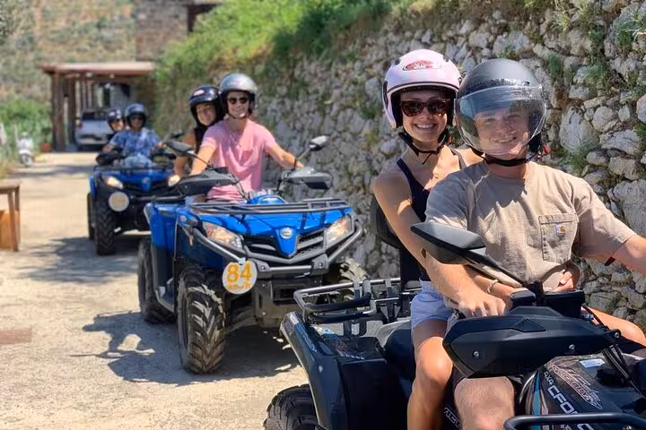 Smiling riders on ATVs exploring the scenic trails of Mount Faito, enjoying an exhilarating quad adventure from Sorrento.
