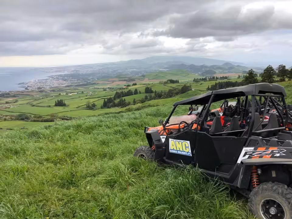 Off-road buggy overlooking lush green hills and coastline on a coast-to-coast half-day adventure tour