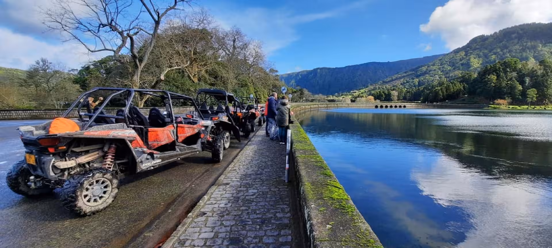 Off-road buggies parked beside Sete Cidades lake on São Miguel, offering a full-day guided excursion with scenic viewpoints