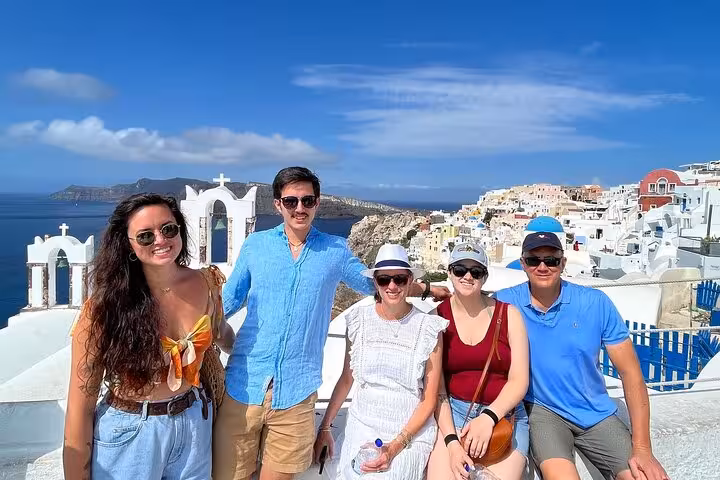 Friends posing in Oia with caldera views on Santorini private tour from Athens, sightseeing and winery tasting