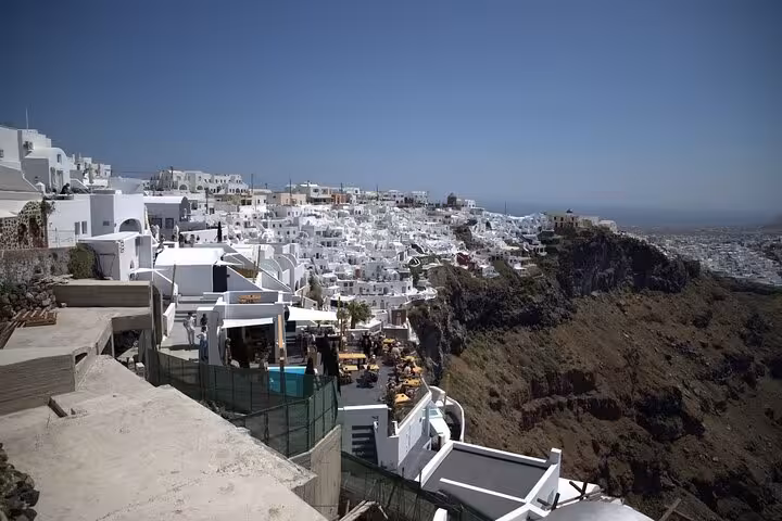 Panoramic Oia village whitewashed cliffside houses over the caldera, top stop on Santorini cruise excursion