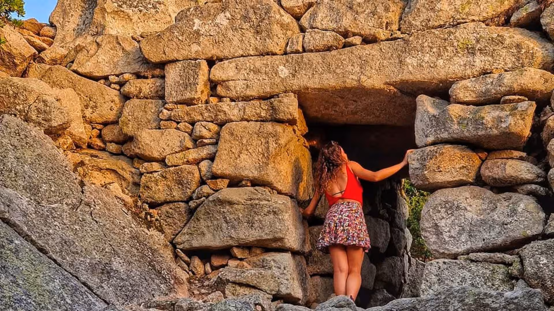 Exploring ancient stone structures in Olbia, a visitor admires the archaeological architecture during a historical tour.