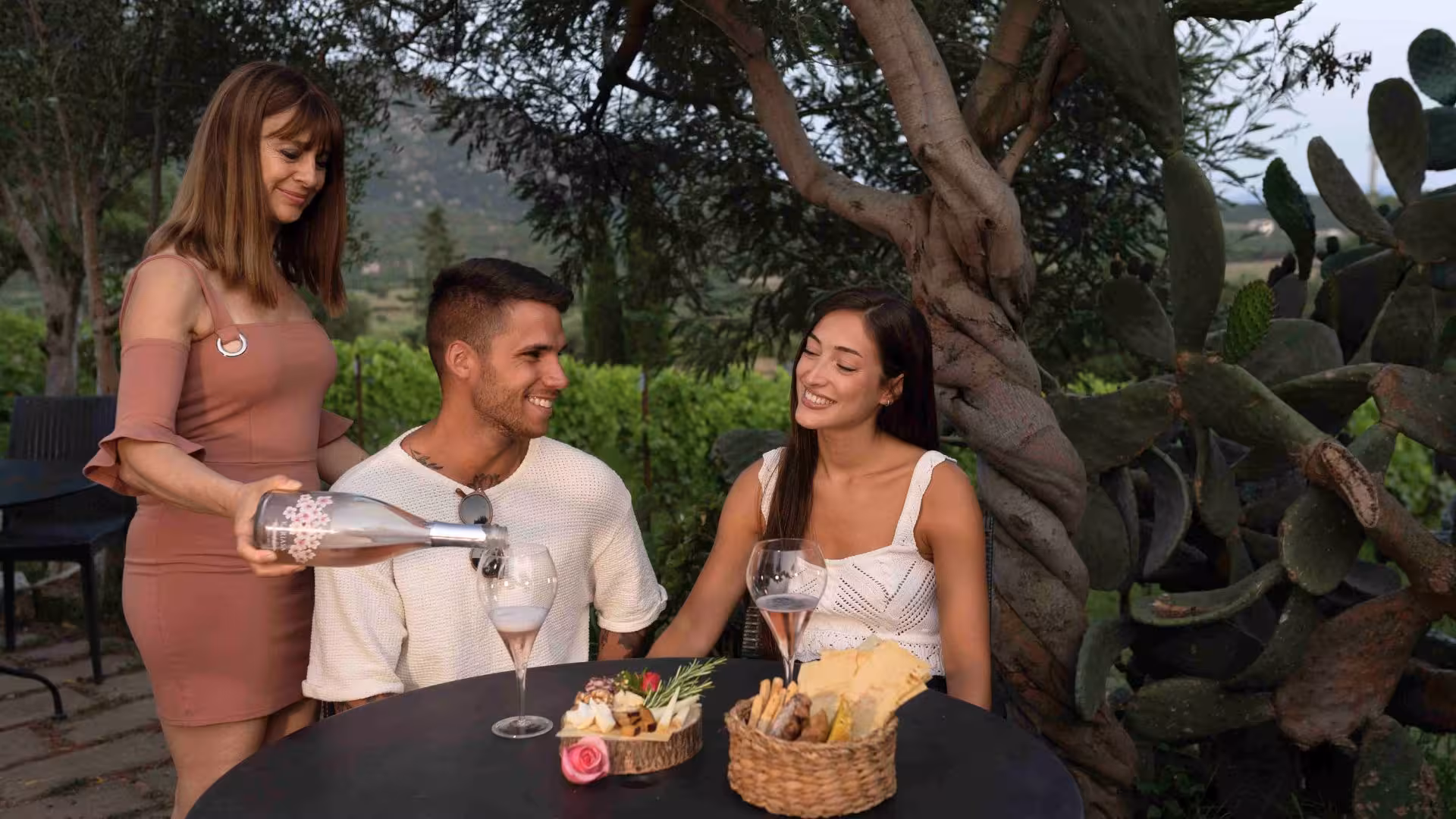Couple enjoying aperitif with wine and cheese at a scenic Gallura winery in Olbia.