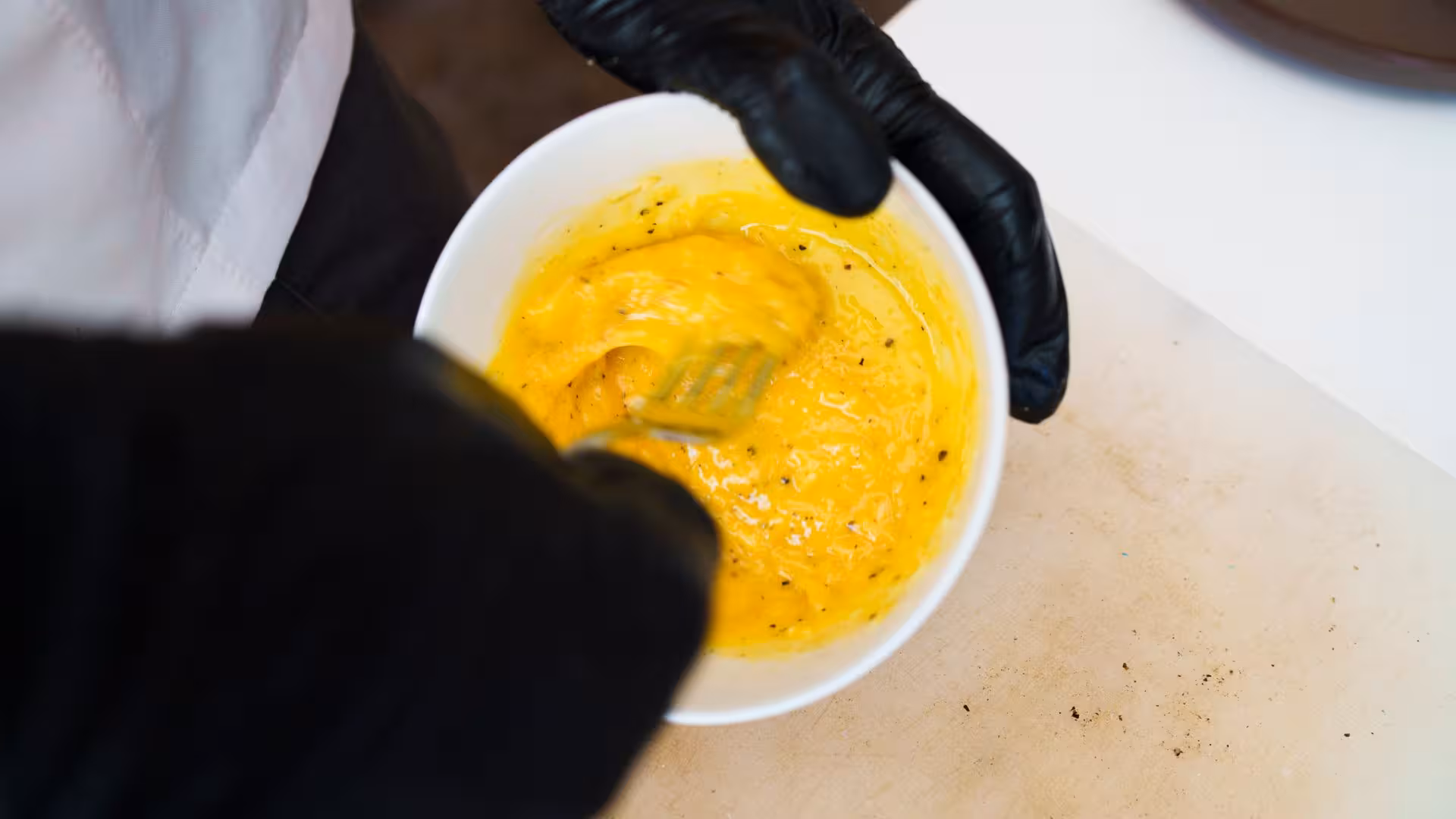Mixing creamy carbonara sauce in a bowl at Olbia cooking class.