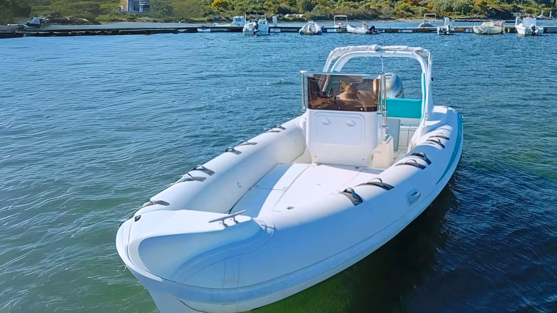 White RIB boat ready for a dolphin-watching adventure in Olbia, docked near Capo Figari's serene waters.
