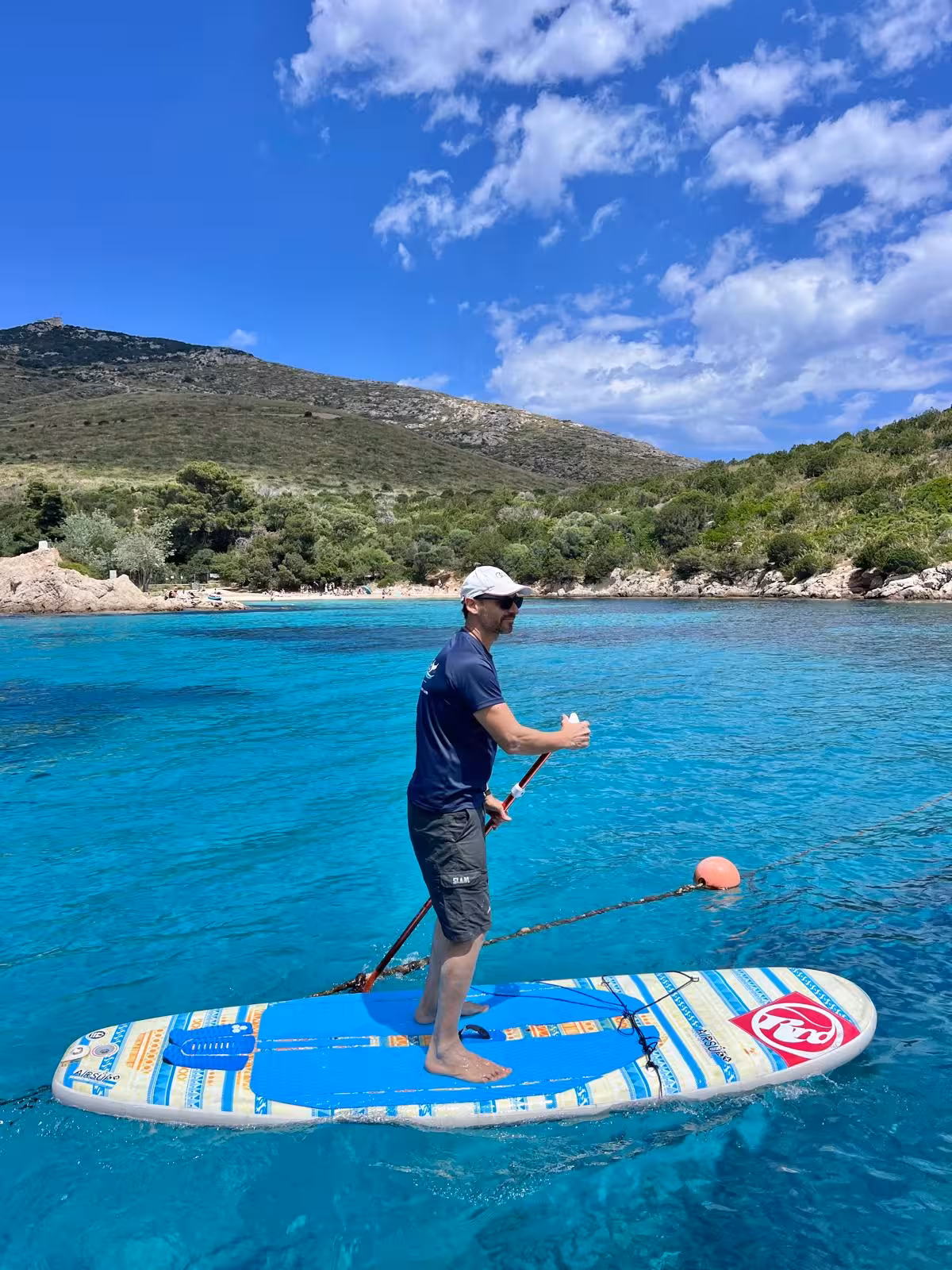 Man enjoying paddleboarding on turquoise waters near Cala Moresca, perfect for adventurous Olbia excursions.