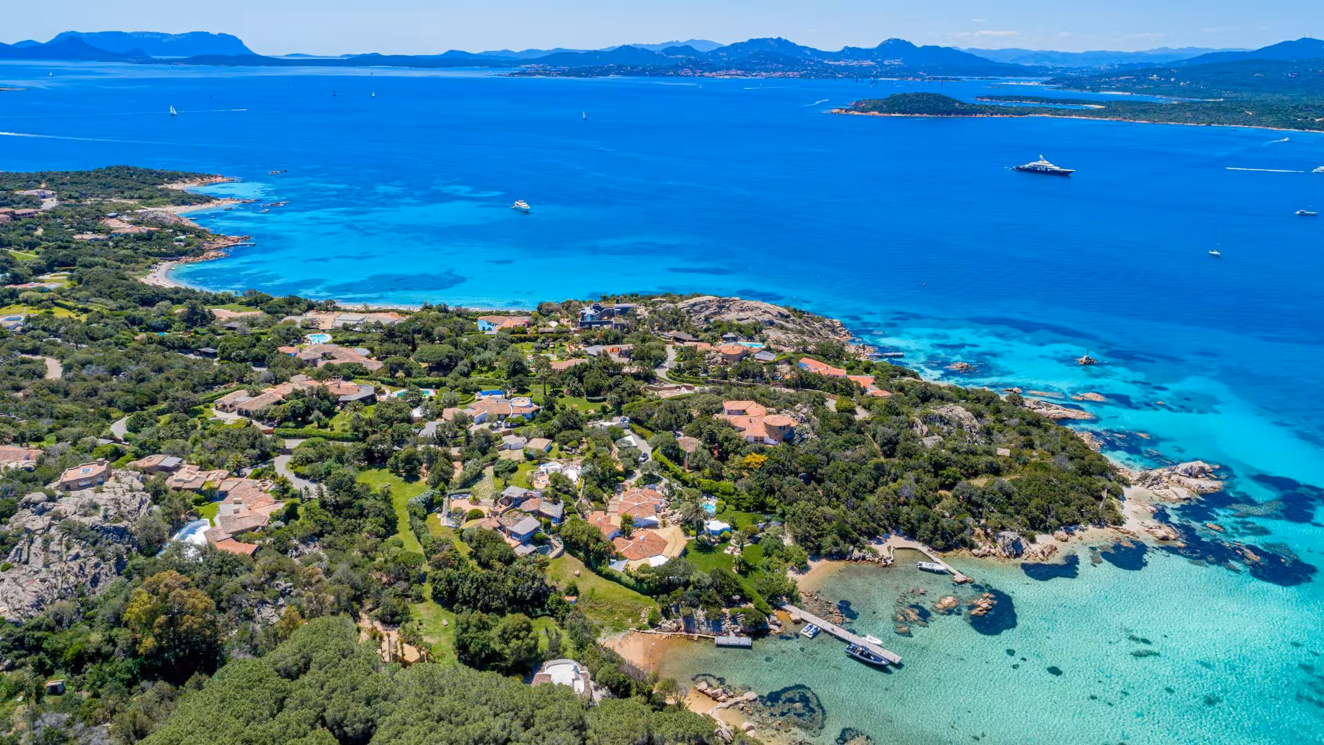 Aerial view of lush coastline and azure waters along the Olbia RIB tour route to Capriccioli.