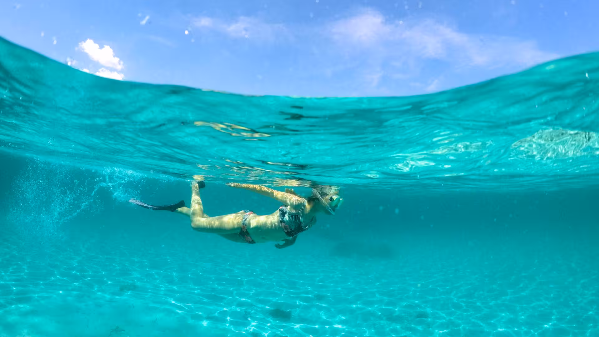 Snorkeler glides underwater in crystal-clear sea near Spiaggia del Principe on the Olbia RIB tour.