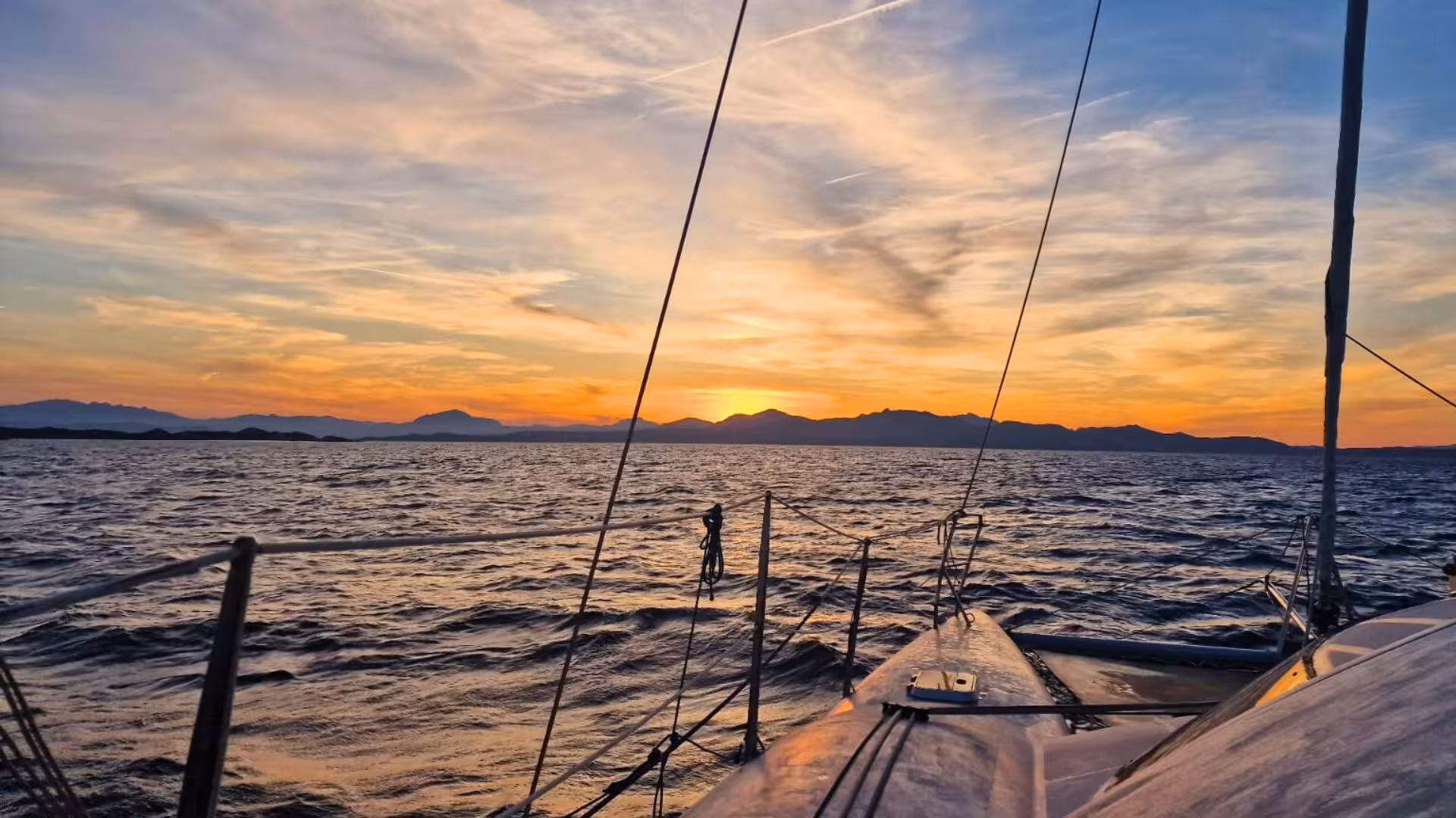 Experience a stunning sunset over Olbia's serene waters from a luxurious catamaran, perfect for a romantic evening tour.