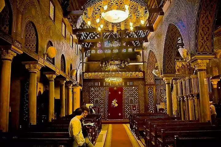 Ornate interior of Old Cairo church with carved columns and chandelier on Alexandria shore excursion