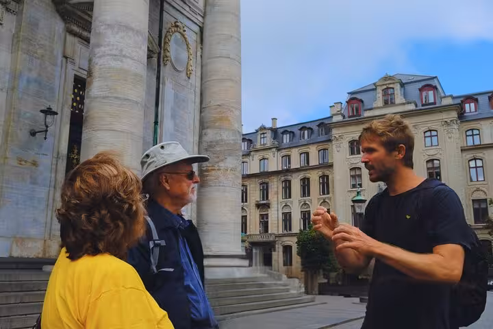 Engaging city tour guide explaining historical details to tourists outside a grand building in Old Copenhagen.