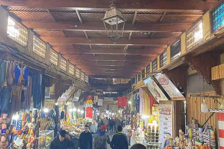 Vibrant market scene with colorful stalls and bustling shoppers in the heart of Old Medina Fez.