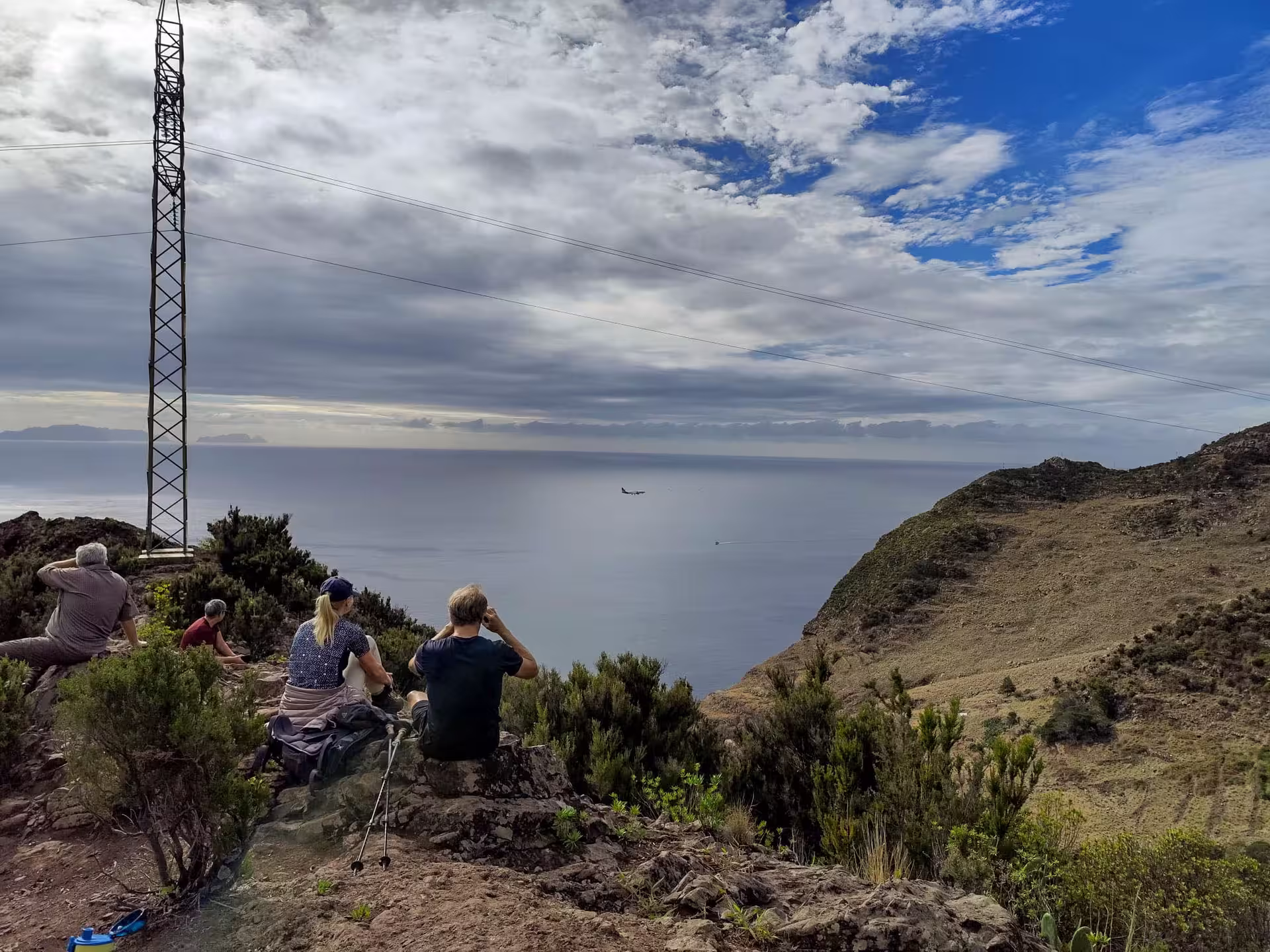 Group of hikers enjoying a scenic ocean view from a hilltop on The Old Path's Hike tour.