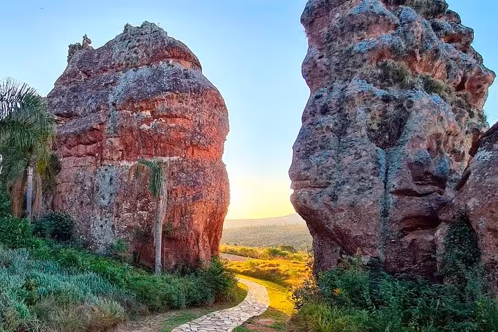 Scenic view of rocky formations and a sunlit path at Old Town State Park's Hole of the Father at sunset.