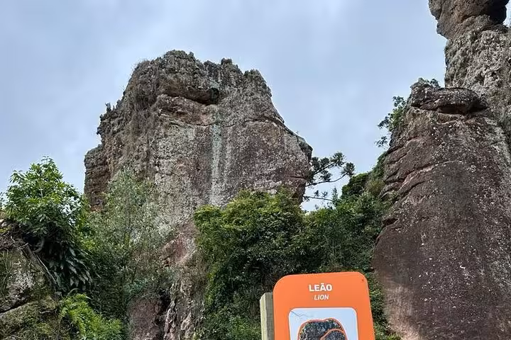 Majestic rock formations at Old Town State Park with lush greenery and a lion signpost.