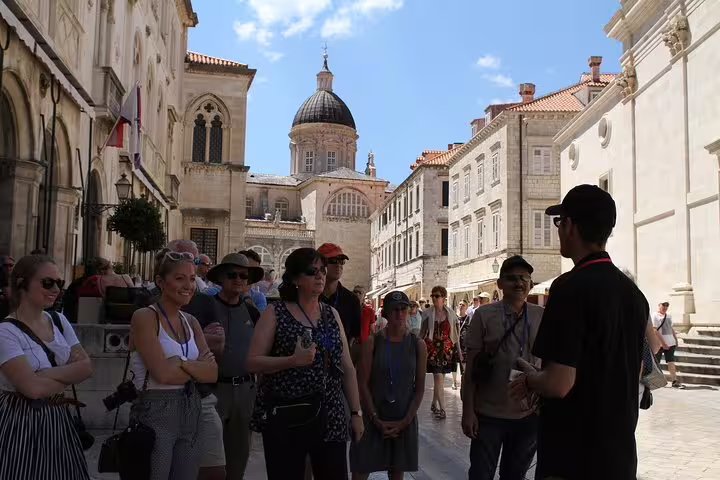 Local guide briefing guests on Old Town walking tour with cathedral dome and limestone streets in the background