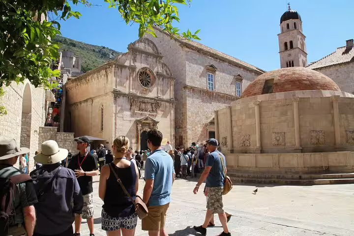 Discover the Old Town Walking Tour at historic church and fountain square with guide and visitors exploring