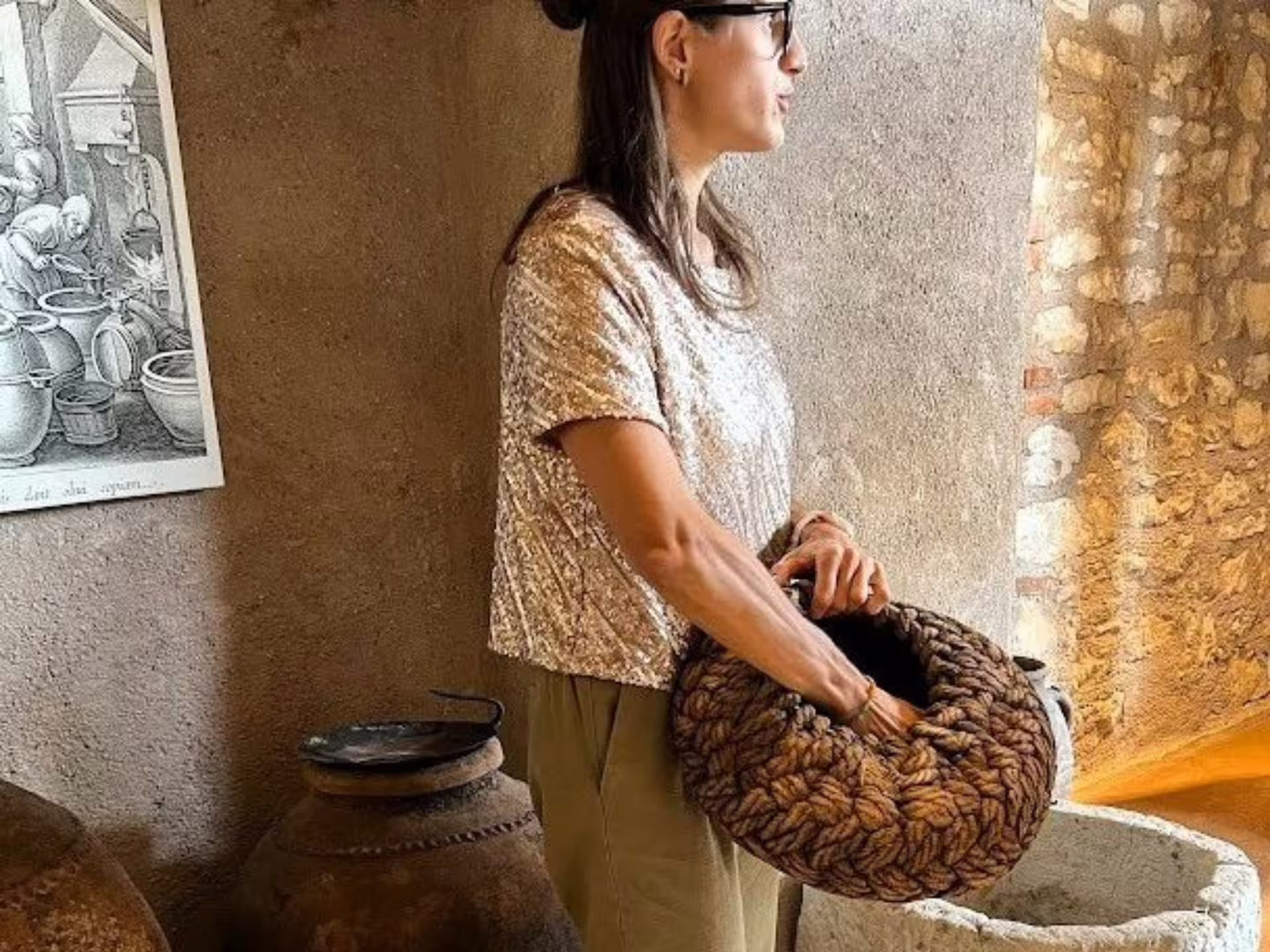 Guide explains olive harvesting with basket during Verona countryside olive mill tour and extra virgin olive oil tasting
