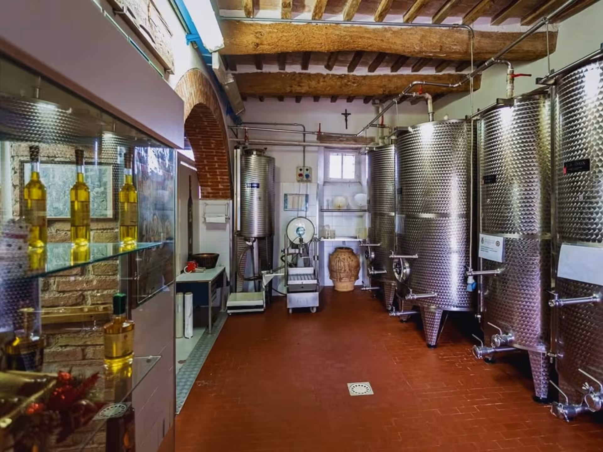 Interior of an olive oil mill in Perugia featuring stainless steel tanks and bottled oils.