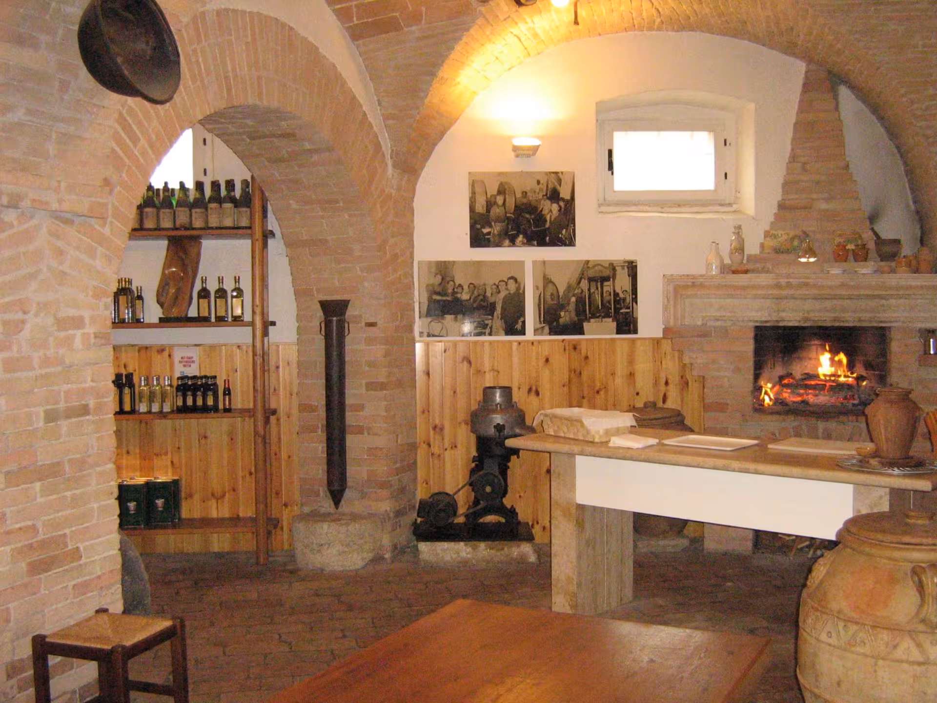 Cozy olive oil tasting room in Perugia with rustic decor and a warm fireplace ambiance.