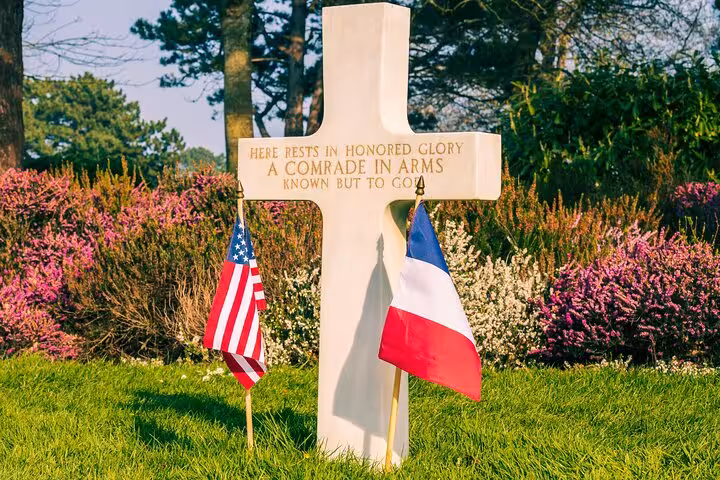 White cross grave marker with US and French flags at Omaha Beach American Cemetery, Normandy