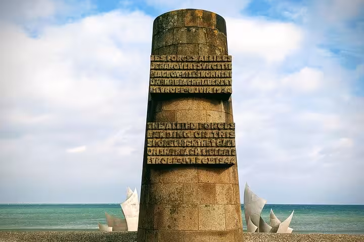 D-Day memorial monument on Omaha Beach Normandy with Allied Forces inscription and sea backdrop