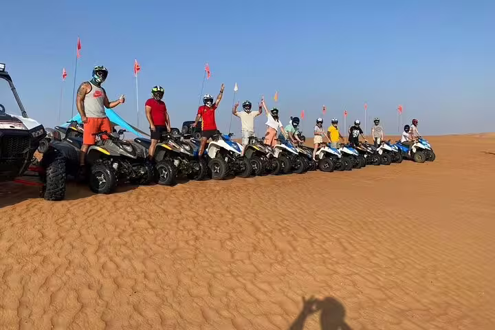 Group enjoying thrilling ATV ride on golden desert dunes during 5 Days 4 Nights Oman Package Tour Mohammed.