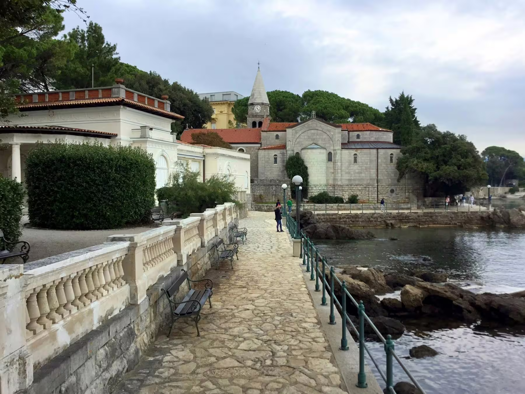 Opatija Lungomare promenade by the Adriatic and historic church, scenic walk on Kvarner Bay tour